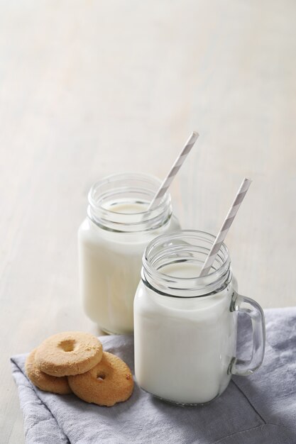 Milchgläser und Kekse auf Holztisch