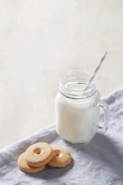 Milchglas und Kekse auf Holztisch