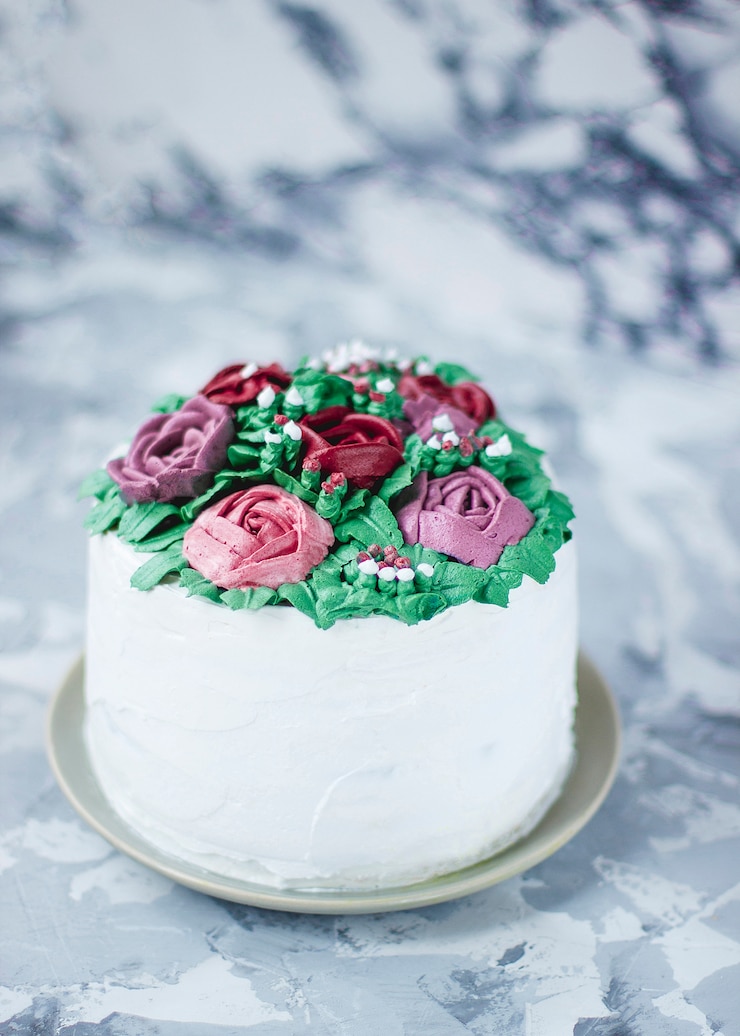 Kostenlose Foto milchige mädchenkuchenscheibe verzierte grünblätter und lilienblumen, der kuchen, der als blumenblumenstrauß verziert wurde, frühlingskuchendekor