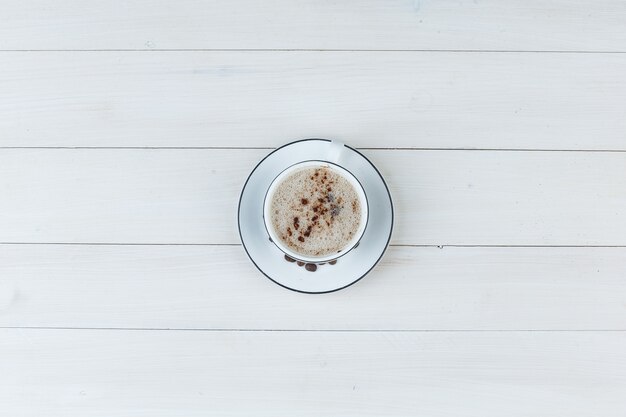 Milchkaffee in einer Tasse auf einem hölzernen Hintergrund. Draufsicht.
