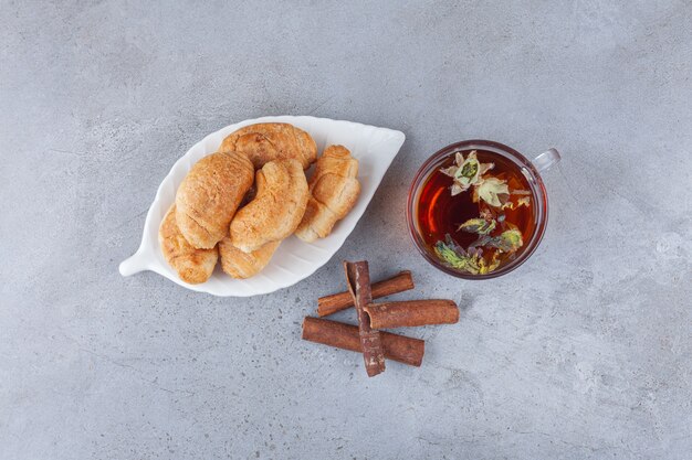 Mini-Croissants aus Blätterteig mit goldener Kruste und einer Tasse Tee.