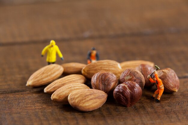Miniatur-Arbeiter arbeiten mit Mandeln und Nüssen
