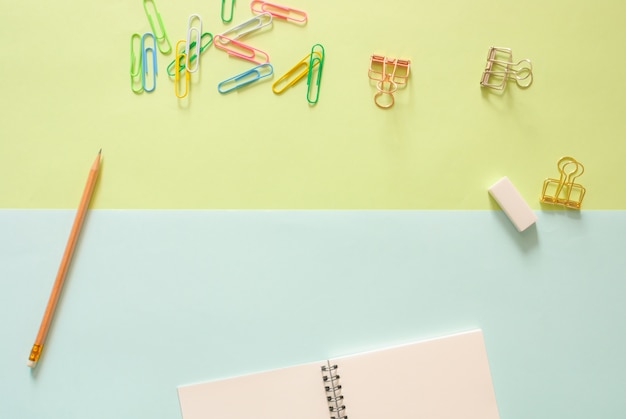 Minimaler Arbeitsraum - Kreativ flach legen Foto von Arbeitsbereich Schreibtisch mit Skizzenbuch und Holz Bleistift auf Kopie Raum grün und blau Pastell Hintergrund. Draufsicht, flache Laienfotografie.