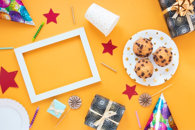 Minimalistische Anordnung der Draufsicht mit Geburtstagsgeschenken und kleinen Kuchen