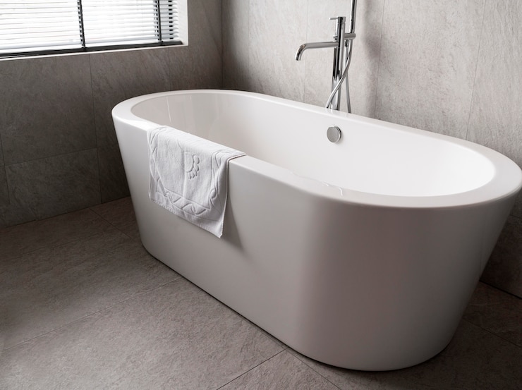 Kostenlose Foto minimalistische weiße badewanne mit handtuch drauf