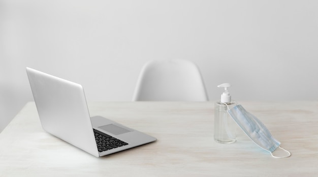 Minimalistischer Büro-Laptop und Schutzmaske mit Gel