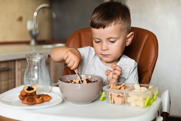 Mischende Getreide des kleinen Jungen in einer Schüssel