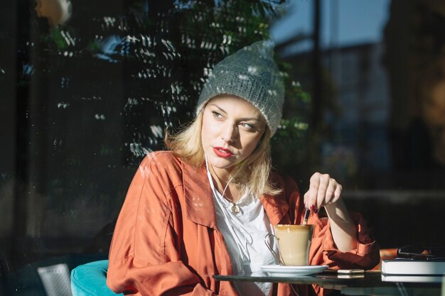 Mischender Kaffee der Frau im Café