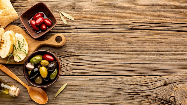 Mischung aus Oliven in Schalen und Brot mit textfreiraum