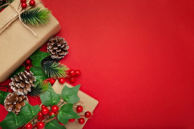 Mistel, Tannenzapfen und Weihnachtsgeschenke auf rotem Tisch