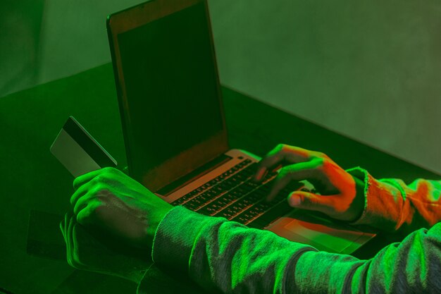 Mit Kapuze Computerhacker, der Informationen mit Laptop stiehlt