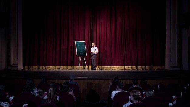 Mit Studenten sprechen. Sprecherin in der Halle des Workshops. Geschäftszentrum. Rückansicht der Teilnehmer im Publikum. Konferenzveranstaltung, Schulung.