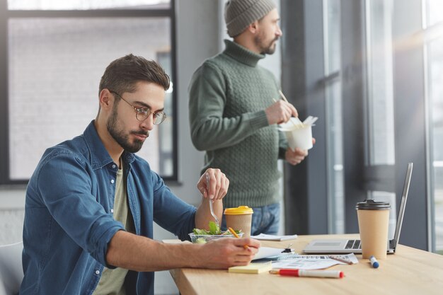 Mitarbeiter beim Mittagessen im Büro