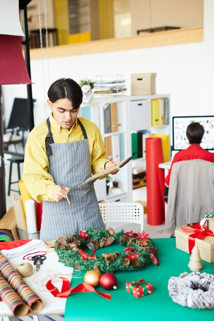 Mitarbeiter, der einen Weihnachtskranz macht