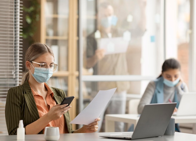 Mitarbeiter, die im Büro Gesichtsmasken tragen