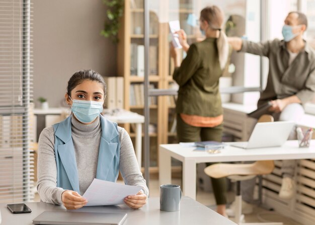 Mitarbeiter, die im Büro Gesichtsmasken tragen