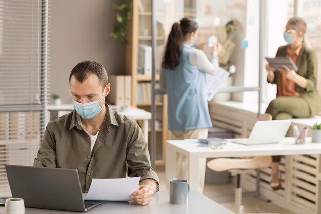 Mitarbeiter, die mit Gesichtsmasken arbeiten