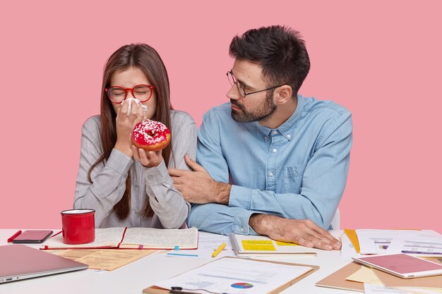 Mitarbeiter sitzen am Schreibtisch mit Dokumenten und Geräten