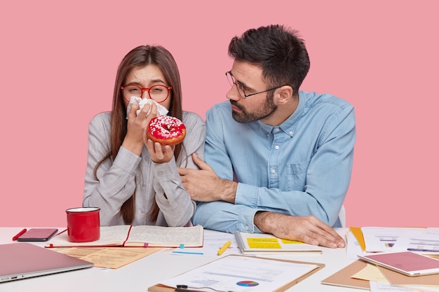 Mitarbeiter sitzen am Schreibtisch mit Dokumenten und Geräten