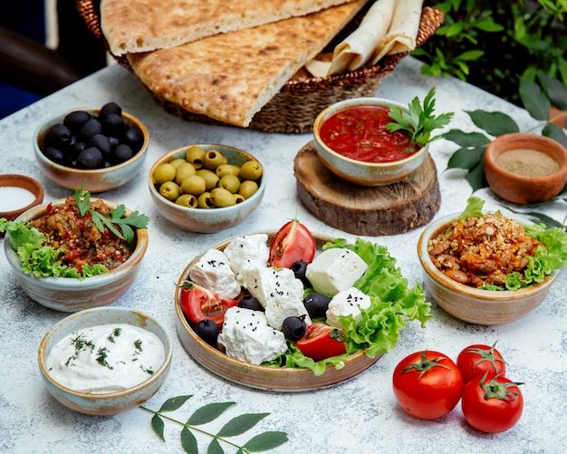 Mittagessen im Freien mit Salaten, Oliven und Brot