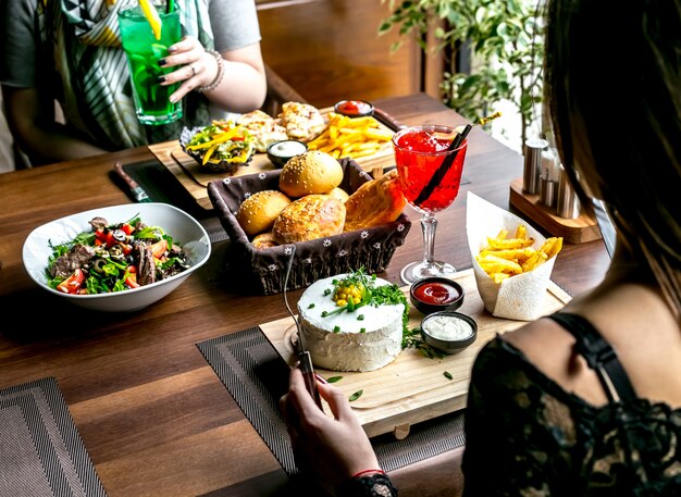 Mittagessen mit Salat Hauptgerichten Brot und Getränke Seitenansicht