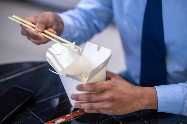 Mittagszeit. Geschäftsmann, der sein Mittagessen am Arbeitsplatz isst