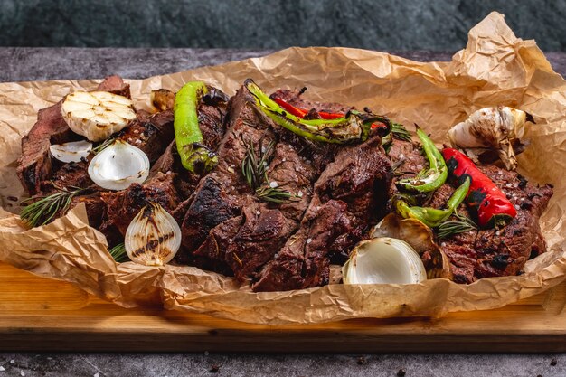 Mittel gekochtes Steak mit Knoblauchzwiebelrot und Chili auf Pergamentpapier