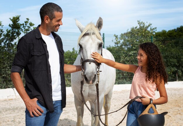 Mittelgeschossener Mann und Mädchen mit Pferd