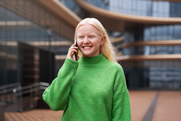 Mittelgroße Albino-Frau, die am Telefon spricht