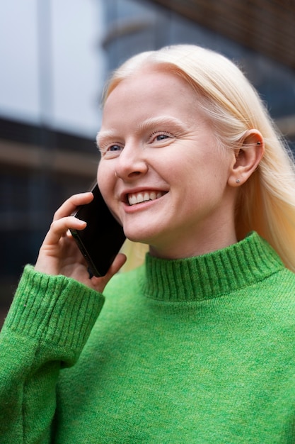 Kostenloses Foto mittelgroße albino-frau, die am telefon spricht