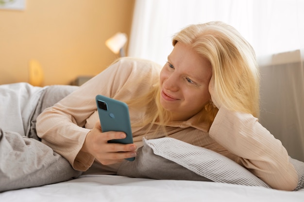 Kostenloses Foto mittelgroße albino-frau mit smartphone