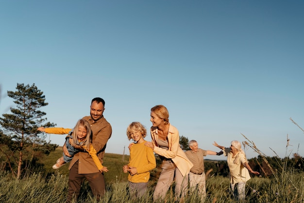 Mittelgroße Familie, die Spaß auf der Wiese hat