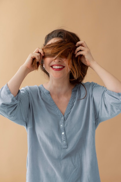 Mittelgroße Frau, die die Augen mit Haaren bedeckt