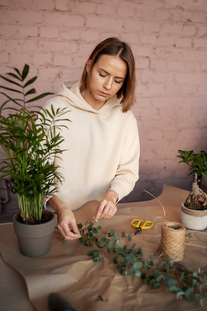 Kostenloses Foto mittelgroße frau, die im blumenladen arbeitet?