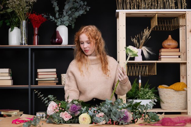 Mittelgroße Frau, die im Blumenladen arbeitet