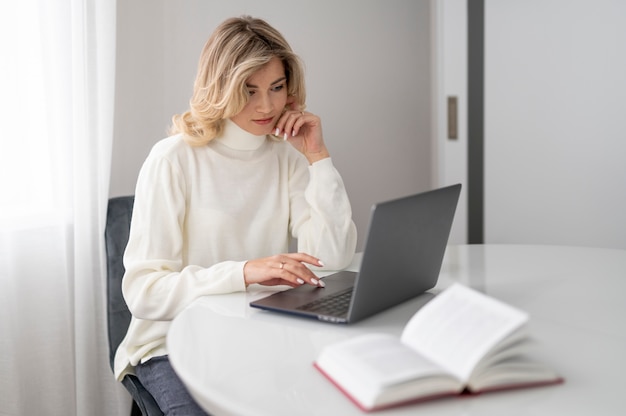 Mittelgroße Frau, die mit Laptop arbeitet