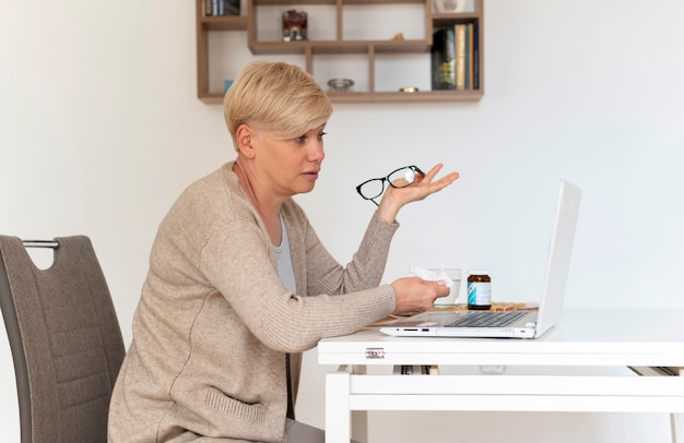 Kostenloses Foto mittelgroße frau mit laptop im haus