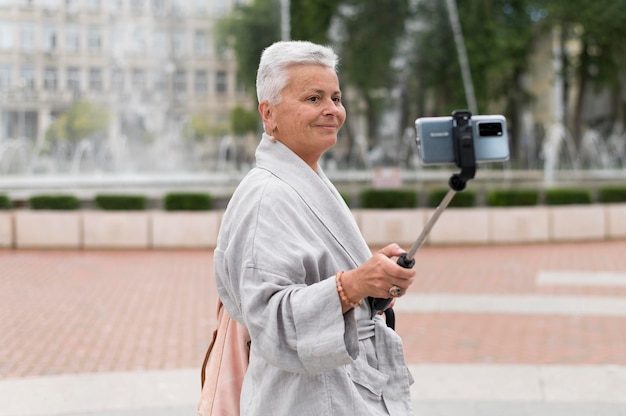 Mittelgroße Frau mit Selfie-Stick