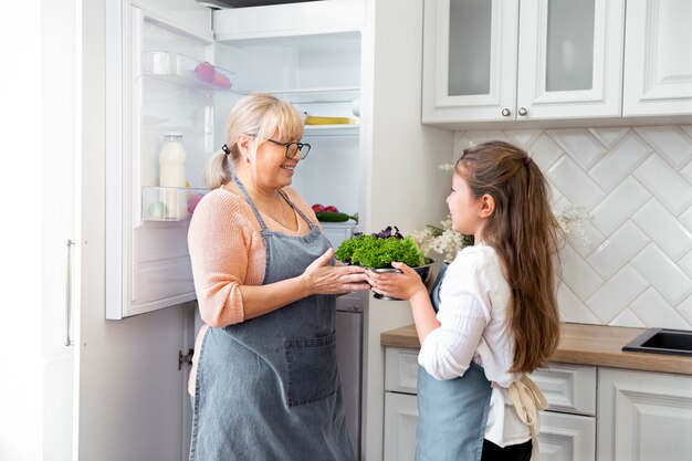 Mittelgroße Frau und Mädchen mit Salatschüssel