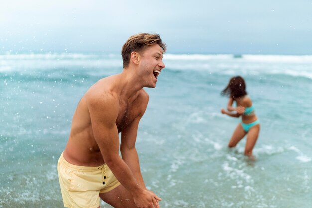 Mittelgroße Freunde, die am Meer spielen