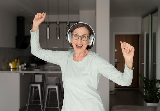 Mittelgroße glückliche Frau mit Kopfhörern