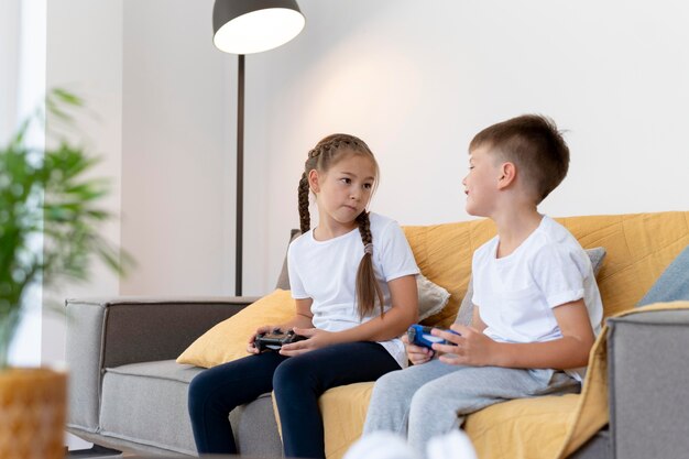 Mittelgroße Kinder, die auf der Couch spielen