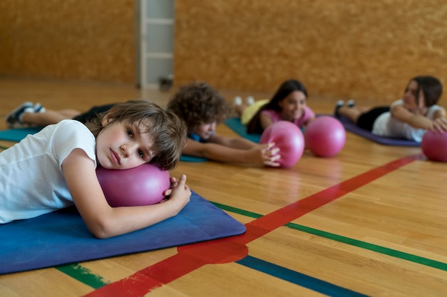 Kostenloses Foto mittelgroße kinder, die auf yogamatten liegen