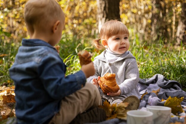 Mittelgroße Kinder, die draußen zusammensitzen