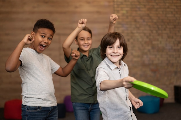 Mittelgroße Kinder, die mit Frisbee spielen