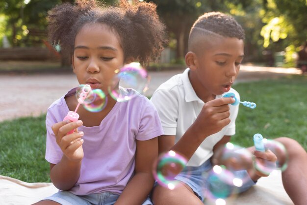 Mittelgroße Kinder machen Seifenblasen