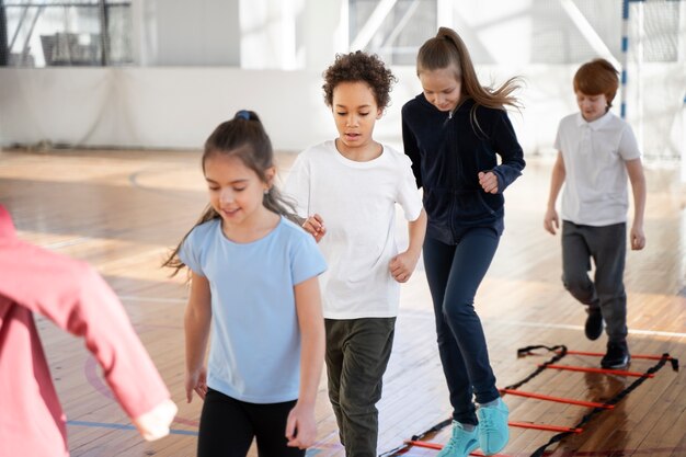 Mittelgroße Kinder trainieren gemeinsam im Fitnessstudio