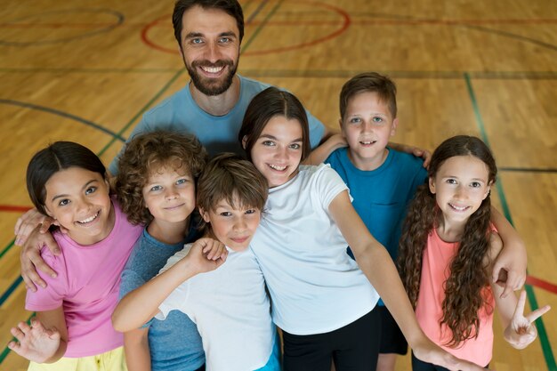 Mittelgroße Kinder und Lehrer posieren