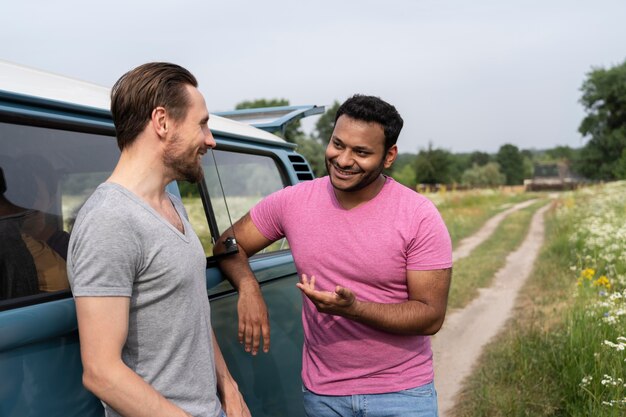 Mittelgroße Männer, die in der Nähe des Vans plaudern