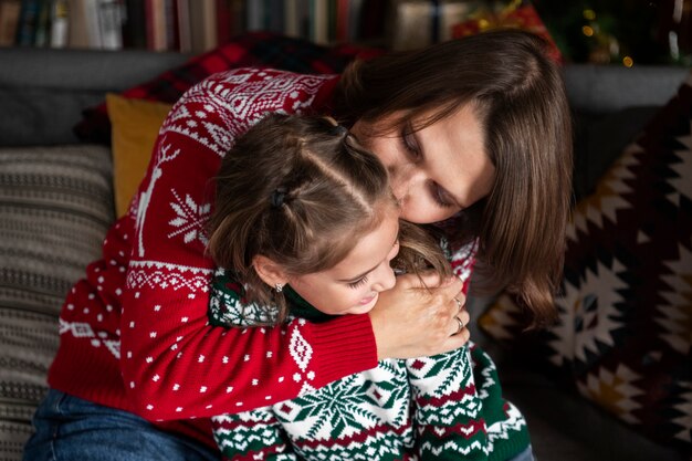 Mittelgroße Mutter, die Kind küsst